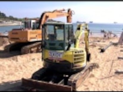 Veraneantes y excavadoras comparten sitio en la playa de El Sardinero, todavía en reparación desde el temporal de invierno