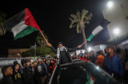 Un hombre con banderas de Palestina celebra el anuncio de acuerdo de alto el fuego entre Hamás e Israel, en Deir al Balah, en el centro de la Franja, este miércoles.
