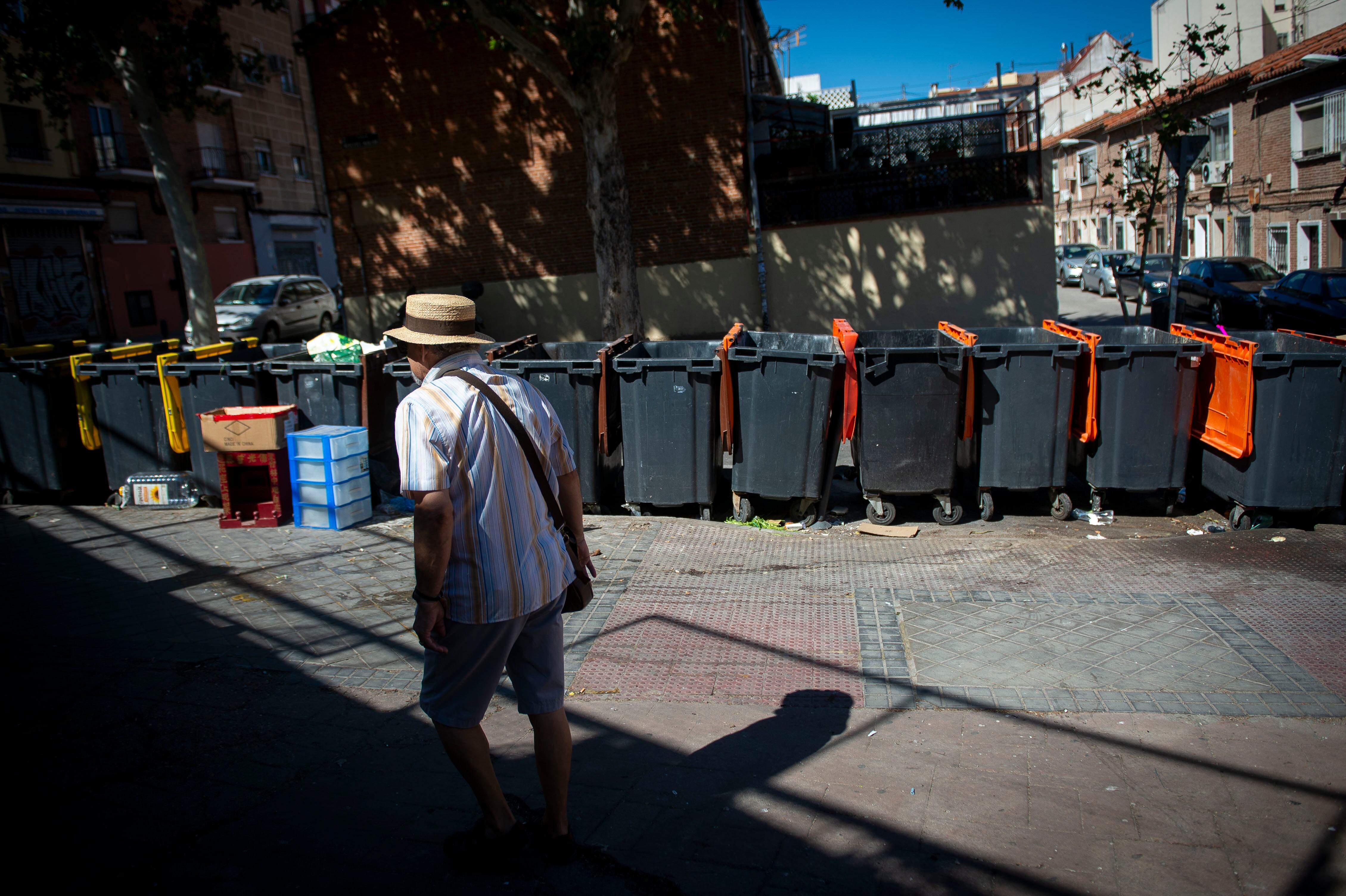 Un hombre pasea junto a unos contenedores en el barrio de Usera, el jueves.
