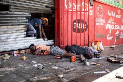 Saqueadores sudafricanos yacen en el suelo después de que agentes de la policía sudafricana intervinieran durante un disturbio en el suburbio de Turffontein, en Johannesburgo, Sudáfrica. Los manifestantes enojados han saqueado presuntas tiendas de propiedad extranjera en una nueva ola de violencia contra ciudadanos extranjeros.