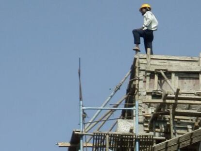 Un trabajador en lo alto de un edificio en construcci&oacute;n en la India.