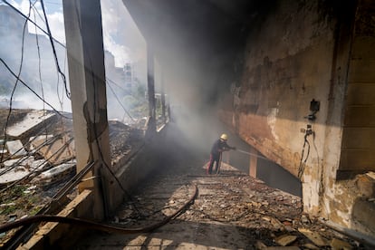 Un bombero apaga las llamas de un edificio afectado por un bombardeo en el barrio de Dahiyeh en Beirut, este miércoles. 