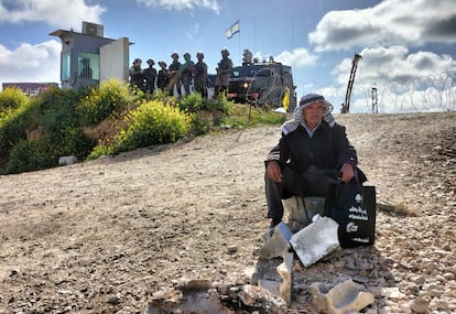 Un anciano descansa sobre una piedra frente a uno de los accesos al puesto de Qalandia.