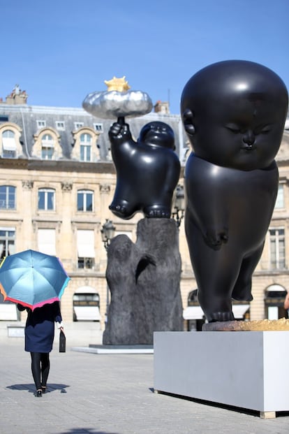 Una mujer pasa junto a las esculturas del artista taiwanés Chen Li 'Palacio flotante Celestial' y 'Parpadeo luz de la luna'