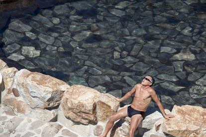 Un hombre toma el sol en la zona fluvial del río Miño y las termas de Outariz, en Ourense.