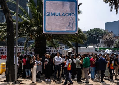 Un grupo de oficinistas se concentra sobre el camellón de Paseo de la Reforma. 