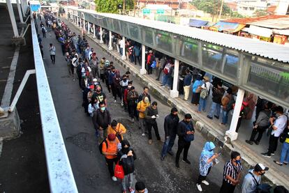 Los pasajeros esperan un tren colocados en filas para mantener la distancia social, en Bogor (Indonesia).