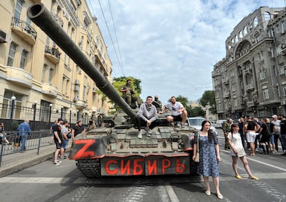 Civilians take a picture on one of the tanks of the Wagner group in the city of Rostov. 