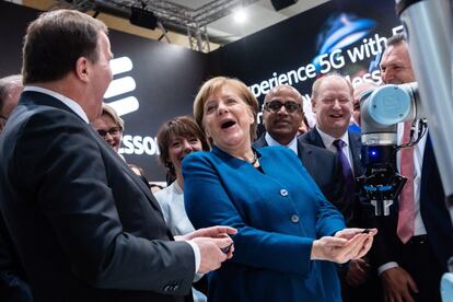 La canciller alemana,Angela Merkel, y el primer ministro sueco, Stefan Loevfen, visitan el estand de la compañía Ericsson durante la inauguración de la Feria de Hannover, en Alemania.