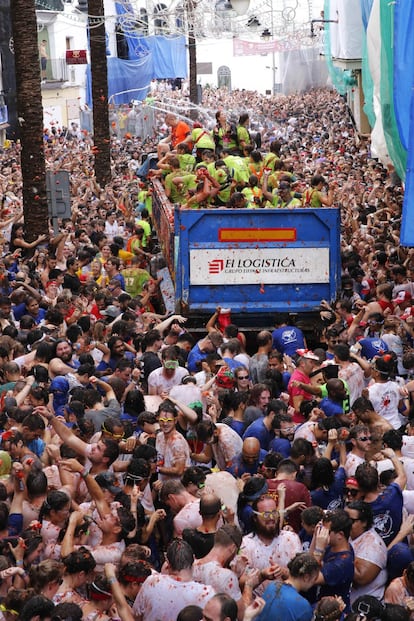 Una multitud se lanzan tomates durante el paso del camión.