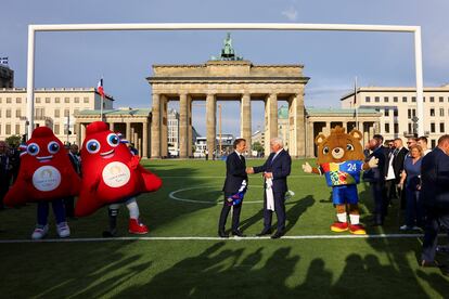 El presidente alemán, Frank-Walter Steinmeier, y el mandatario francés, Emmanuel Macron, se dan la mano en el arranque del verano deportivo germano-francés en la zona de aficionados de la Eurocopa 2024 en Berlín, el 26 de mayo.