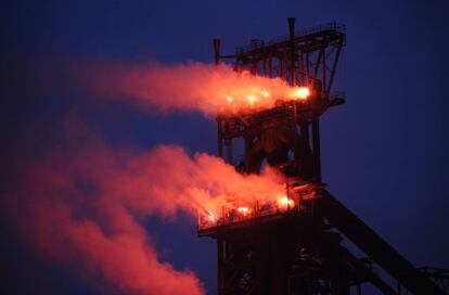 La chimenea de una planta en la ciudad belga de Sclessin donde los trabajadores colocaron focos rojos en se&ntilde;al de protesta por el anuncio del cierre de la factor&iacute;a. 