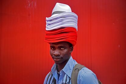 Un vendedor ambulante con una montaña de sombreros en la cabeza, el 6 de julio de 2017.