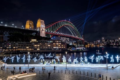 El arte y la tecnología transforman Sídney durante tres semanas. Hasta el próximo 15 de junio, la capital australiana se llena de luz con el Vivid Sydney. Light, Music & Ideas Festival, un gran evento con luces, música, conferencias y talleres. En total, más de 50 instalaciones artísticas de cien artistas se han colocado por el centro de la ciudad, en zonas como Chatswood o los jardines del zoo. La organización propone una ruta, con salida desde Wynyard Station, a través de <a href="https://www.vividsydney.com/guides" target="_blank">este mapa animado.</a> <br></br> En la imagen, la instalación 'Ballerina', del artista italiano Angelo Bonello, en Campbell’s Cove, con el gran puente de la bahía al fondo.