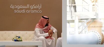 FILE PHOTO: A Saudi Aramco employee sits in the area of its stand at the Middle East Petrotech 2016 in Manama