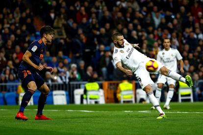 El delantero francés del Real Madrid, Karim Benzema, golpea el balón ante el defensa brasileño del Valencia, Gabriel Paulista.