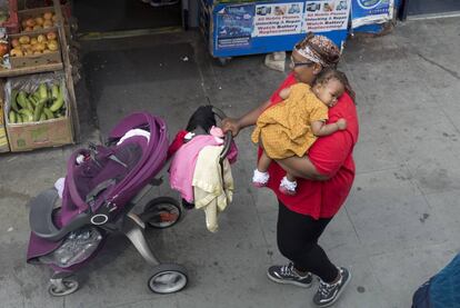 Una madre carga a su bebé en Londres (Inglaterra). 