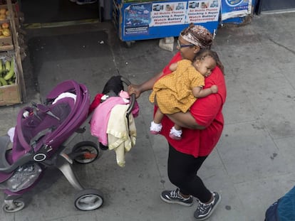 Una madre carga a su bebé en Londres (Inglaterra). 