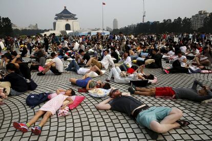 Participantes hacer un descanso durante el Día Internacional de la Batalla de Almohadas en la plaza de La Libertad de Taipe (Taiwán).
