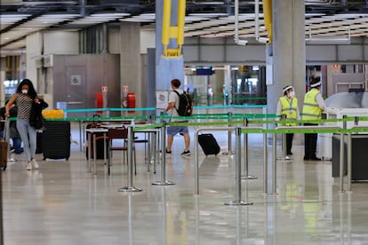 Pasajeros procedentes de Londres caminan entre los pasillos delimitados el 24 de junio de 2020.