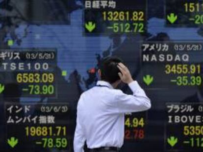 Un empresario observa varios indicadores bursátiles en una calle de Tokio. EFE/Archivo