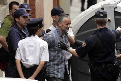 Agentes de la policía conducen a  uno de los supuestos terroristas islamistas, detenido en Santa Coloma de Gramenet.