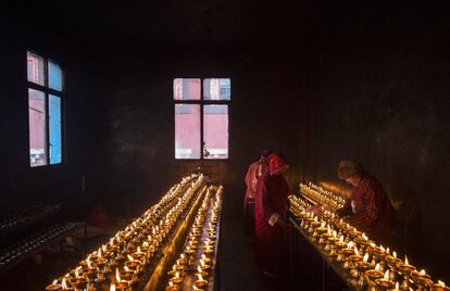 Las monjas budistas mantienen velas encendidas durante la Asamblea Dharma Bliss.