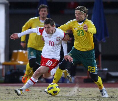 Lithuania's Stankevicius (left) tussles with Poland's Obraniak on the Kaunas pitch during Friday's friendly.