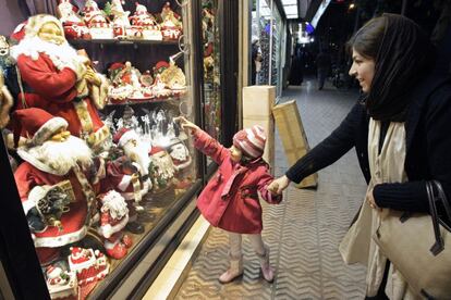 Una niña señala el escaparte de una tienda en el barrio cristiano de Teherán, Irán.