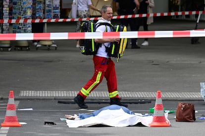 Un sanitario pasa delante del cuerpo sin vida de la víctima mortal del atropello múltiple de este miércoles, una profesora de 51 años que acompañaba a un grupo de adolescentes de excursión en Berlín.  