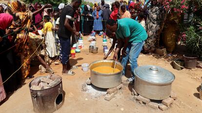 Un voluntario distribuye ayuda a un grupo de personas en Omdurman, al norte de Jartum, a principios de septiembre.
