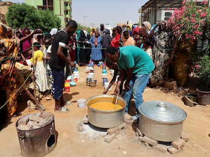 Un voluntario distribuye ayuda a un grupo de personas en Omdurman, al norte de Jartum, a principios de septiembre.