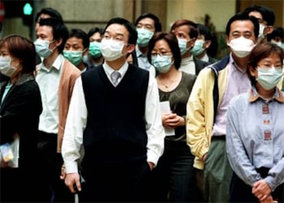 Ciudadanos de Hong Kong caminan por la calle con mascarillas protectoras contra la epidemia.