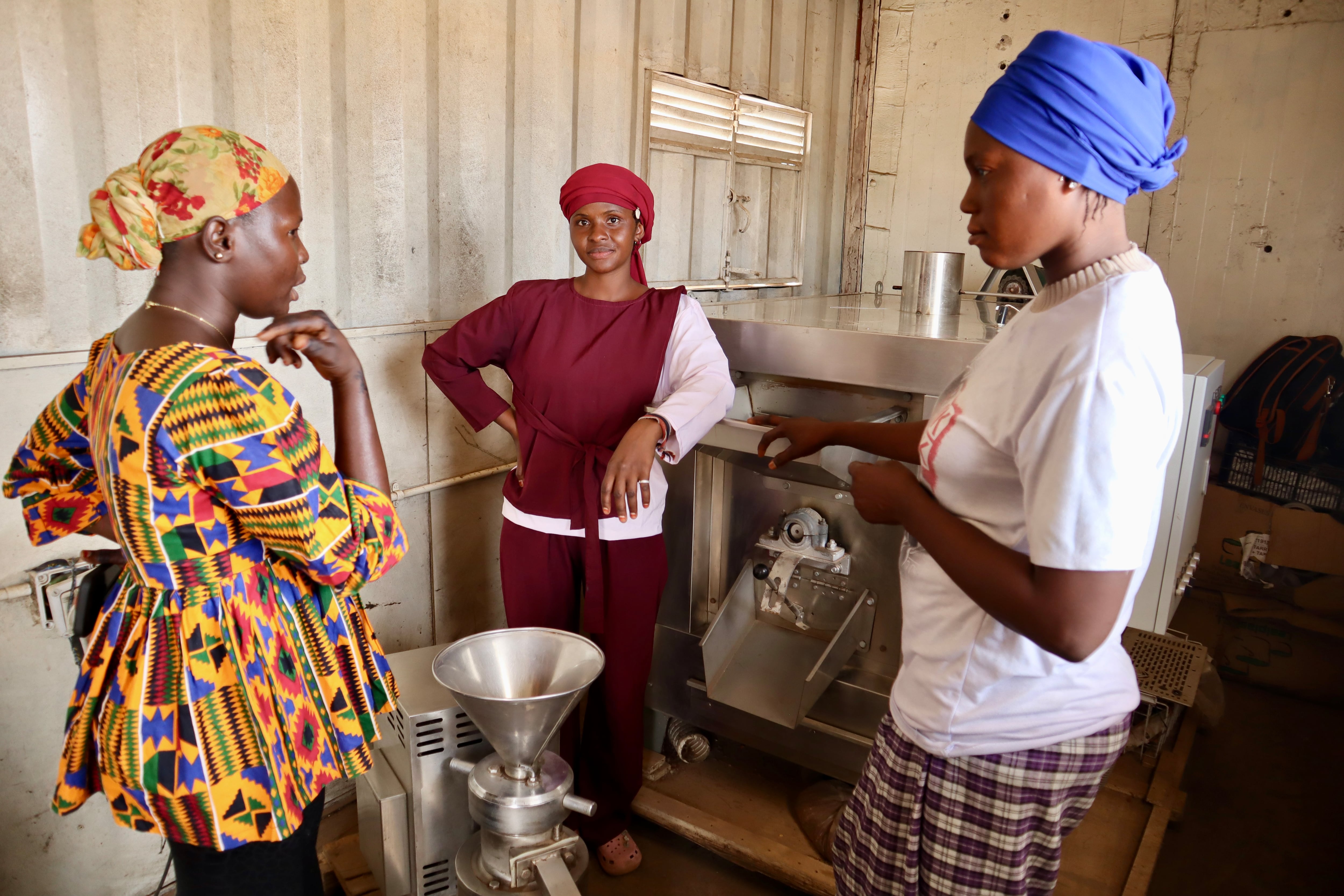 Fatou Njie supervisa el trabajo de Aida Camara y Habbi Njie que gestionan la Plataforma Solar Multifuncional de Fass, el 21 de mayo de 2025.