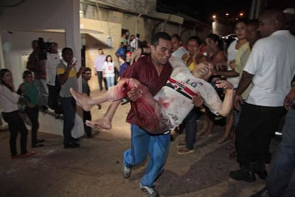 A prisoner from the Pedrinhas prison is carried to receive medical help after he was injured during a fight between rival gangs inside the jail on January 8.