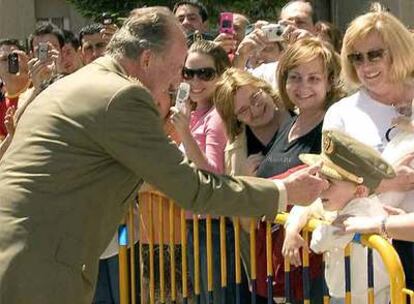 El Rey coloca su gorra a un niño durante la visita que realizó a la sede de la Guardia Civil.