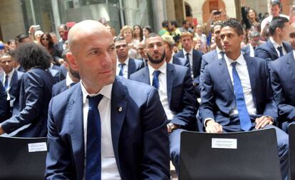 Zidane, en la sede de la Comunidad de Madrid. Detr&aacute;s, Benzema y Varane.