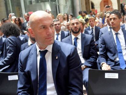 Zidane, en la sede de la Comunidad de Madrid. Detr&aacute;s, Benzema y Varane.