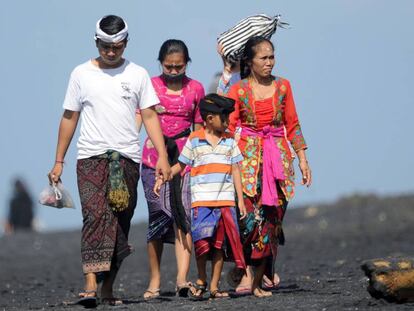 Una familia balinesa pasea por la playa en la localidad de Giangar, en Bali. el 12 de mayo de 2019. 