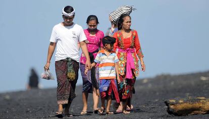 Una familia balinesa pasea por la playa en la localidad de Giangar, en Bali. el 12 de mayo de 2019. 