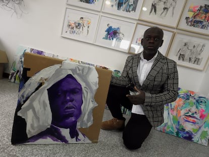 El artista Eduardo Malé, de Santo Tomé y Príncipe, posa con uno de sus cuadros en su estudio de Ponferrada (León).