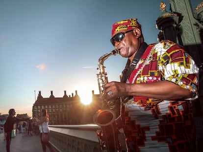 Un saxofonista pone banda sonora a un atardecer en el puente de Westminster, en Londres. 