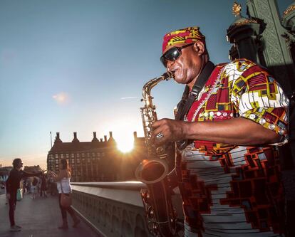 Un saxofonista pone banda sonora a un atardecer en el puente de Westminster, en Londres. 