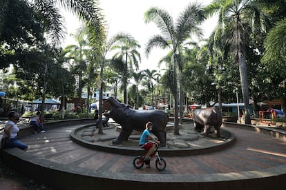 Un niño monta en bicicleta en un parque decorado con estatuas de hipopótamos en Doradal, Colombia, en febrero de 2021. 