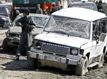 Un policía afgano vigila la zona donde se ha producido el atentado cerca del Ministerio de Justicia en Kabul.