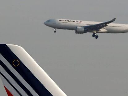 El primer témino, la cola de uno de los aviones de Air France. Detrás, otro aparato de la compañía durante la operación de aterrizaje en el aeropuerto parisino Charles de Gaulle.