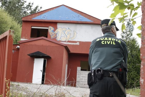 Un guardia civil custodia la entrada del club Queen's, precintado y abandonado, durante un registro de La Carioca.