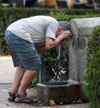 Un hombre se refresca en una fuente de un parque de Madrid el 3 de julio.