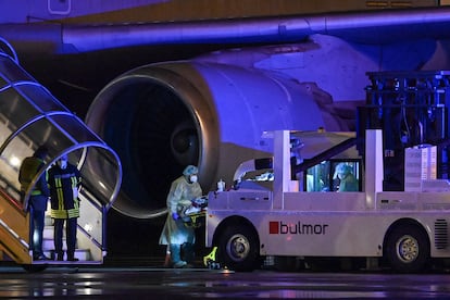 Médicos transportando a enfermos de coronavirus graves en un avión medicalizado.