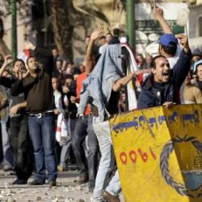 Los manifestantes lanzan piedras durante los enfrentamientos entre partidarios y detractores de Mubarak, en la plaza Tahrir